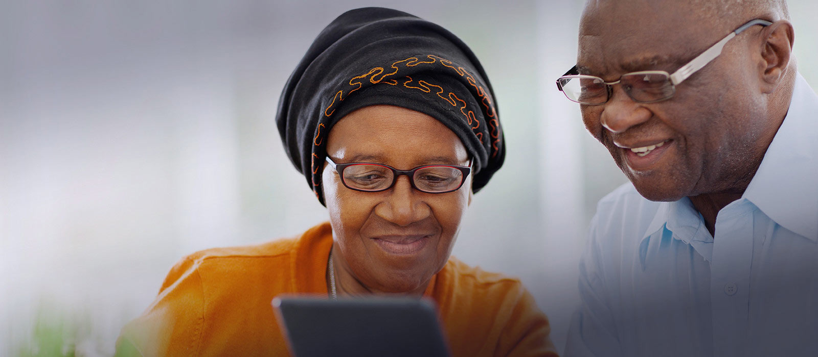 Image of an elderly couple looking an iPad